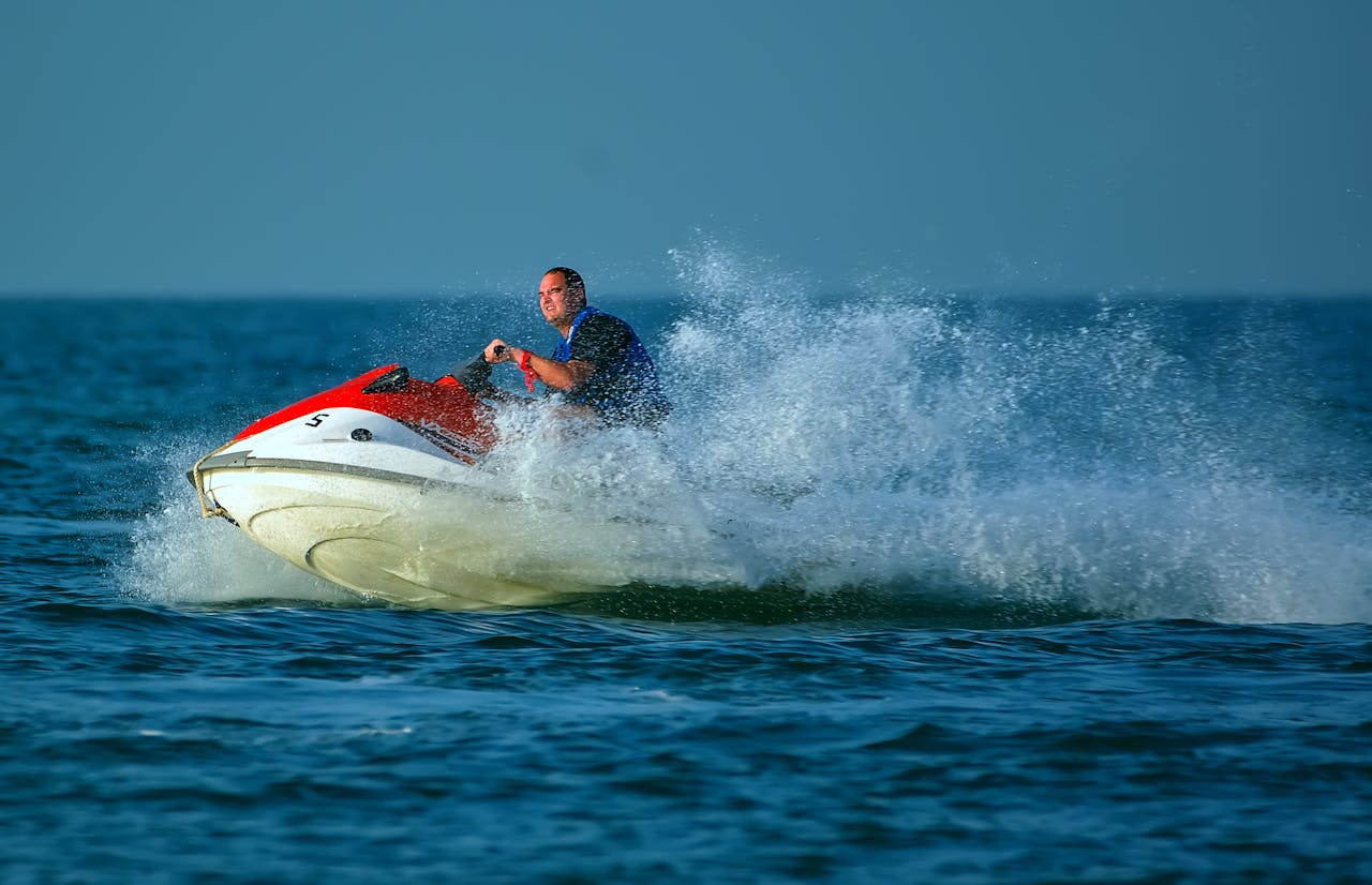 Action-packed scene of a man on a jet ski splashing through the ocean waves.
