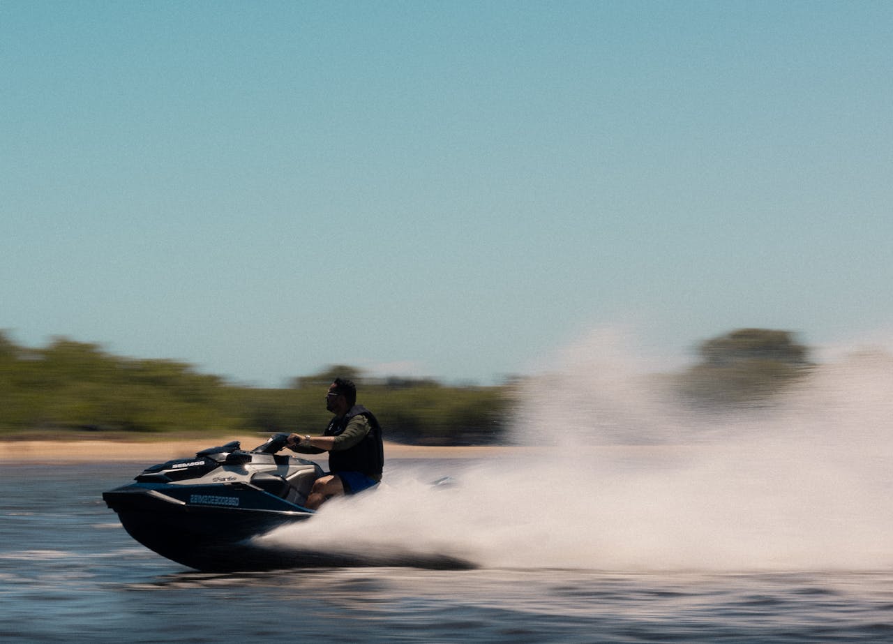 A person enjoying a thrilling ride on a jet ski, creating water spray and capturing a sense of adventure and speed.